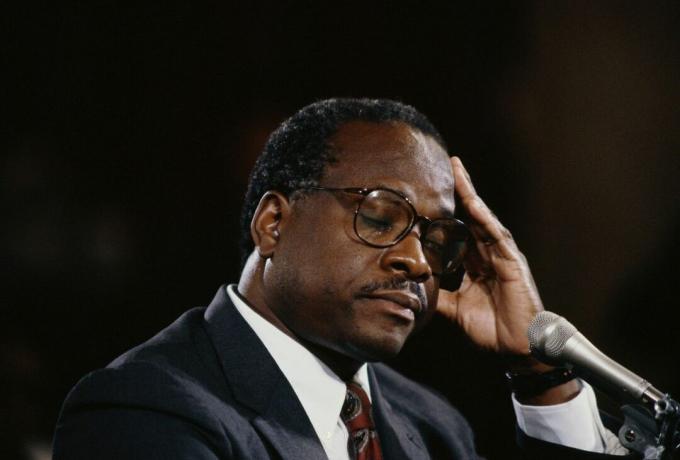 Clarence Thomas sluit zijn ogen en legt zijn hand op zijn hoofd tijdens zijn hoorzitting over de vermeende seksuele intimidatie van Anita Hill.