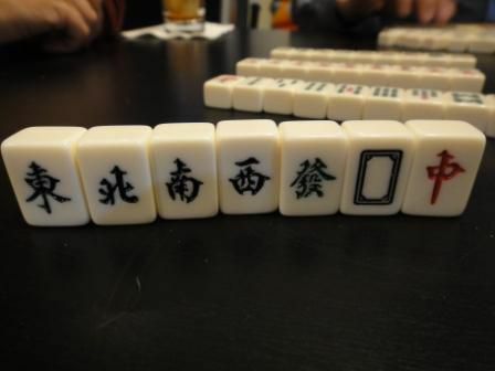 De tegels van de winden en draken in een Mahjong-set rechtop op een tafel.