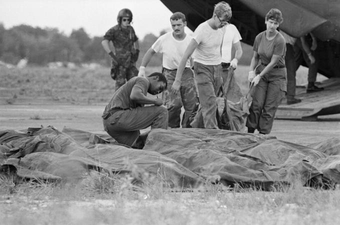 Mensen die lichamen van Jonestown-zelfmoord verwijderen