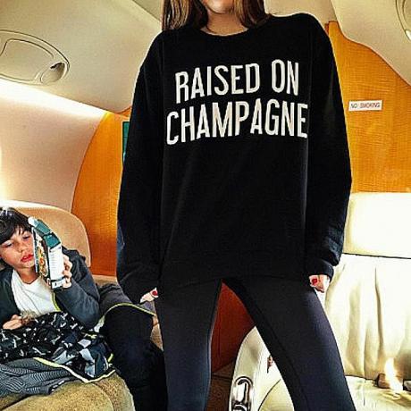 Een foto gepost op Rich Kids van Instagram toont een meisje dat een sweater draagt ​​met de tekst "Opgeheven op Champagne. "Symbolische interactietheorie helpt ons te begrijpen hoe dit shirt en de foto ervan betekenis creëren in de samenleving.