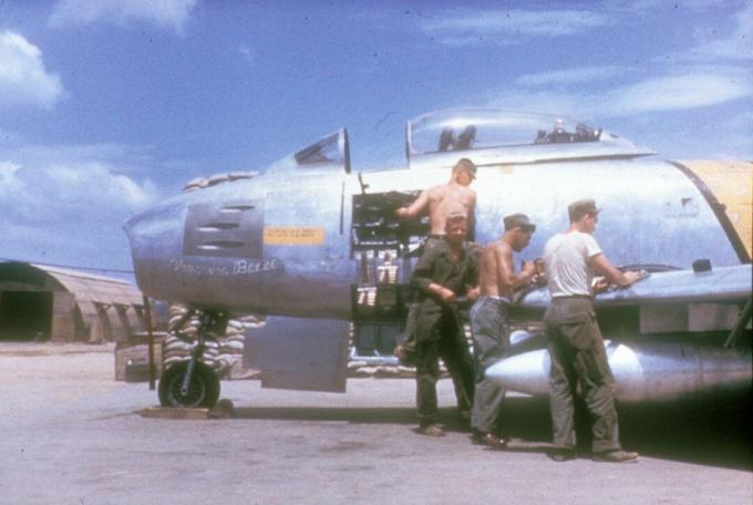 Armorers naast een F-86 Sabre met een zijpaneel verwijderd.