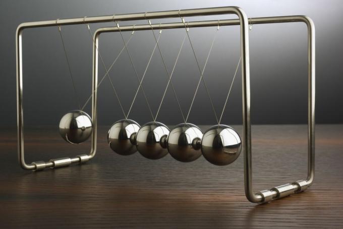 Close up van Newton's Cradle in beweging.