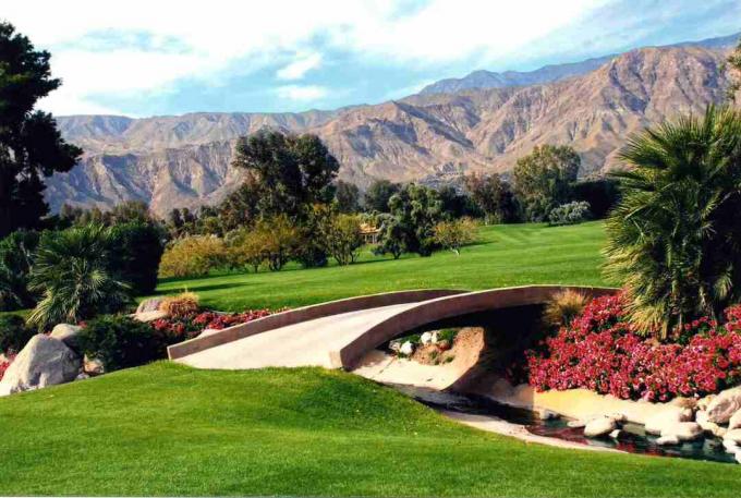 Een brug kruist een beek op de golfbaan met uitzicht op de bergen van Zuid-Californië.