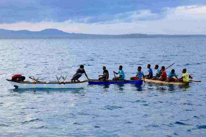 Jonge mannen in kano's in het noordwesten van Malakula, Vanuatu.