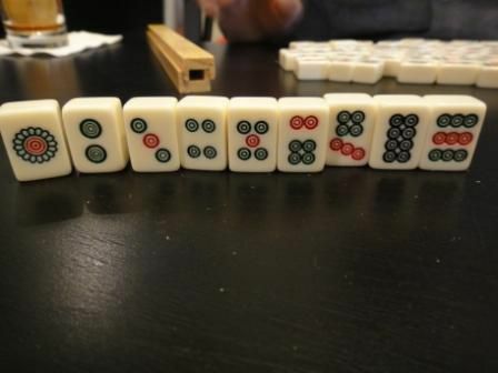 Het stenen pak van een standaard set Mahjong-tegels die op een tafel staan.