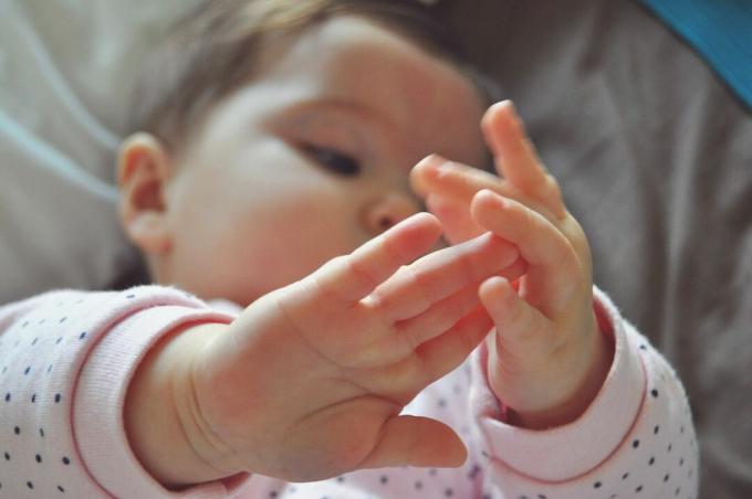 Hoge Hoekmening die van Babymeisje op Bed liggen