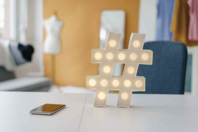 Verlicht hashtag-teken op tafel in modestudio