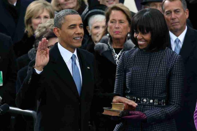 Barack Obama met zijn hand op bijbels die naast zijn vrouw worden beëdigd voor zijn tweede termijn.