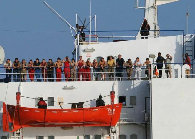 Somalische piraten die het koopvaardijschip MV Faina vasthouden, staan ​​op 19 oktober 2008 met bemanningsleden op het dek van het schip.