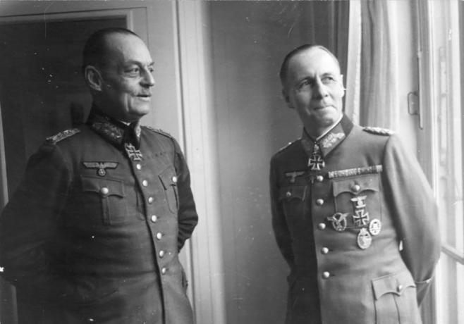 Gerd von Rundstedt en Erwin Rommel in Duitse militaire uniformen die bij een raam staan.