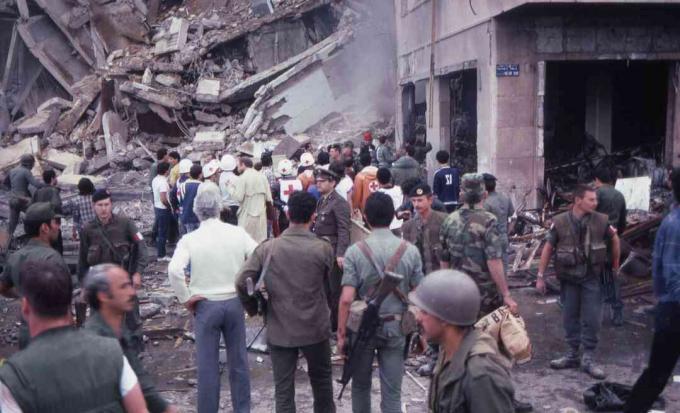 Een menigte soldaten en hulpverleners staat te midden van de vernietiging en schade op de plaats van de zelfmoordaanslag op de Amerikaanse ambassade, Beiroet, Libanon, 18 april 1983.